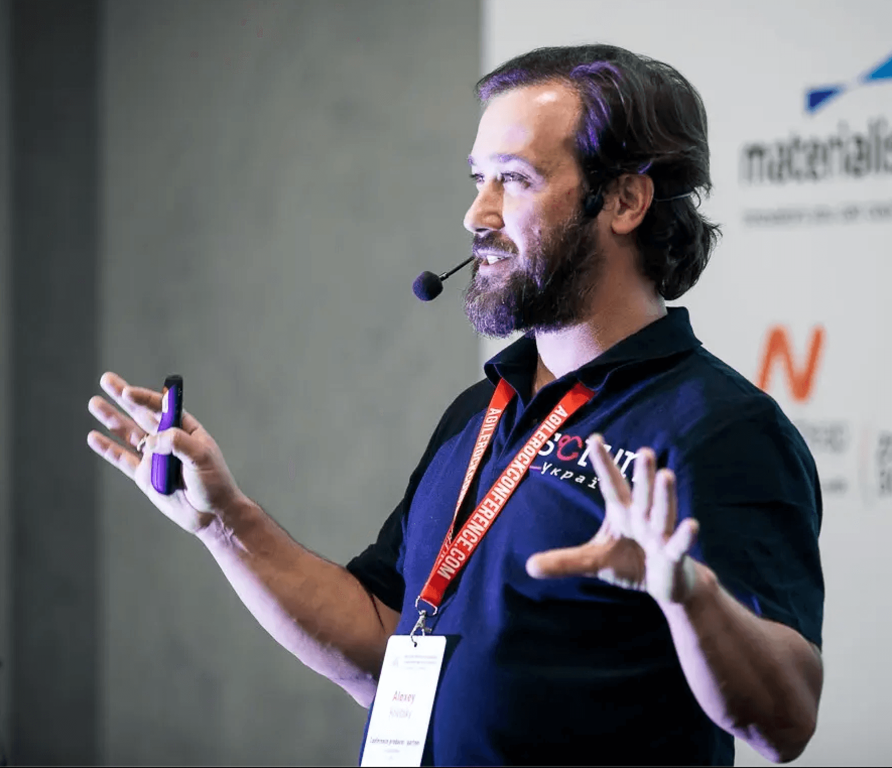 Alexey Krivitsky, AI and Org Design consultant, speaking on stage with a headset microphone