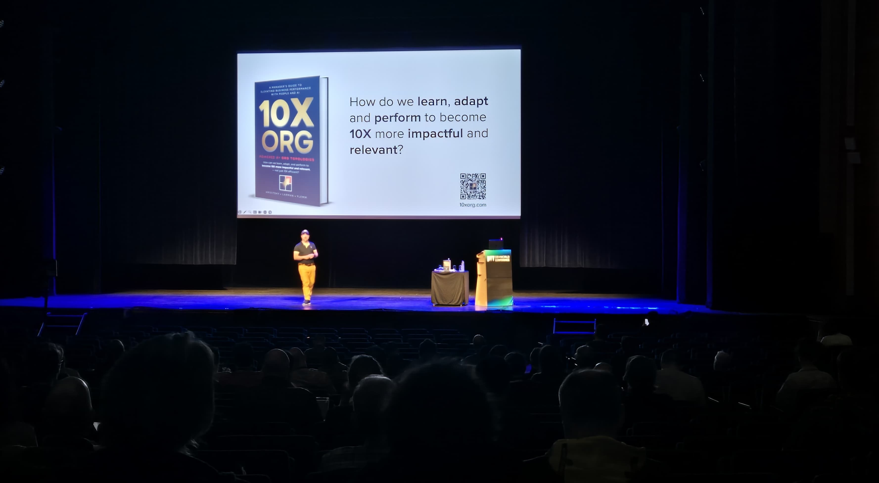 Alexey presenting 10X ORG on a large conference stage